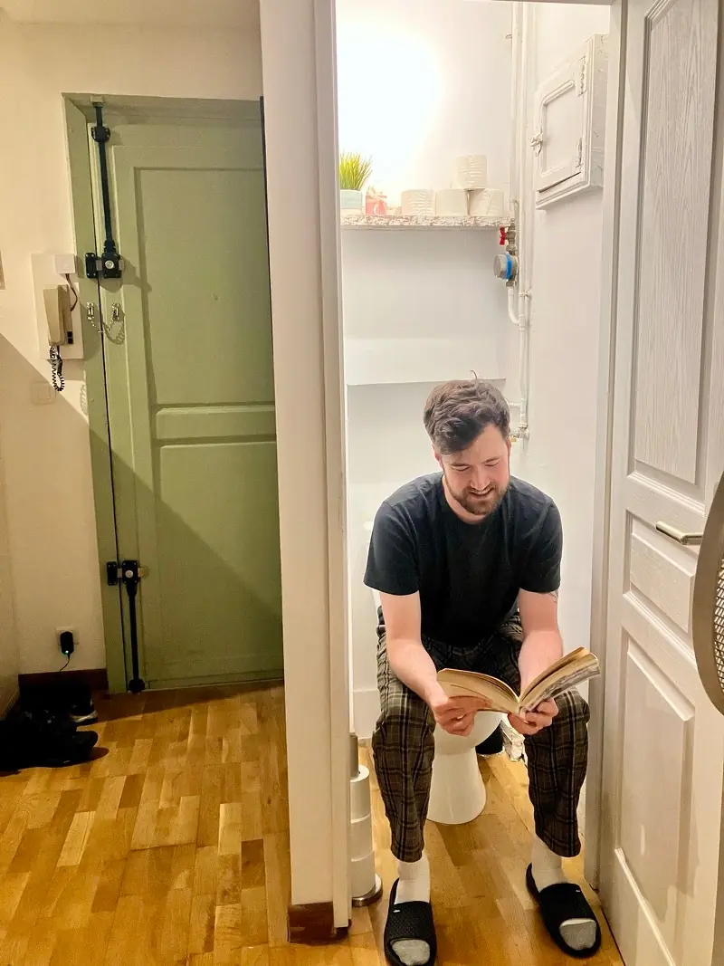 Front view of Nate sitting in a French toilet